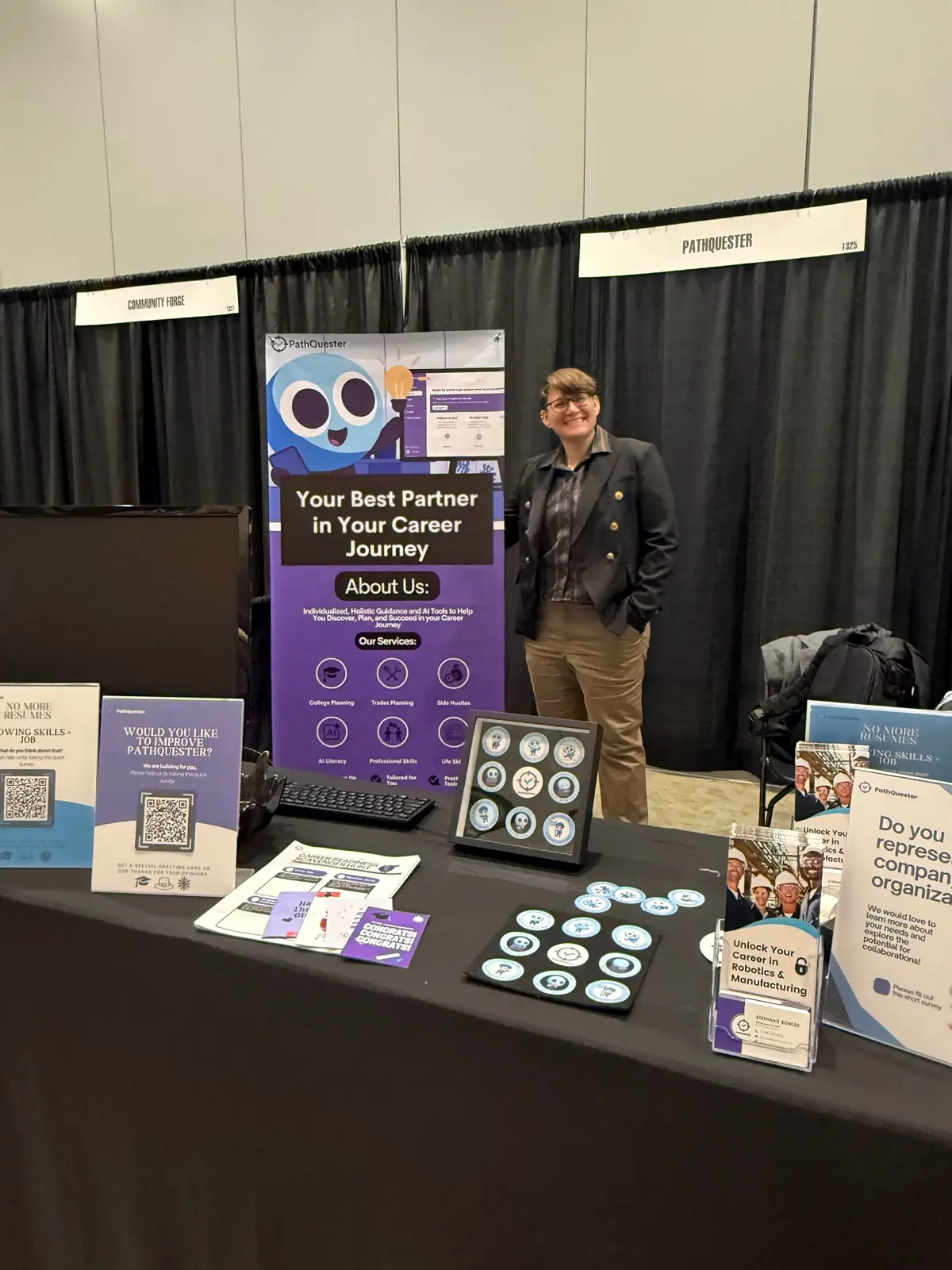Dr. Stephanie Bowles standing beside the PathQuester booth at a trade show