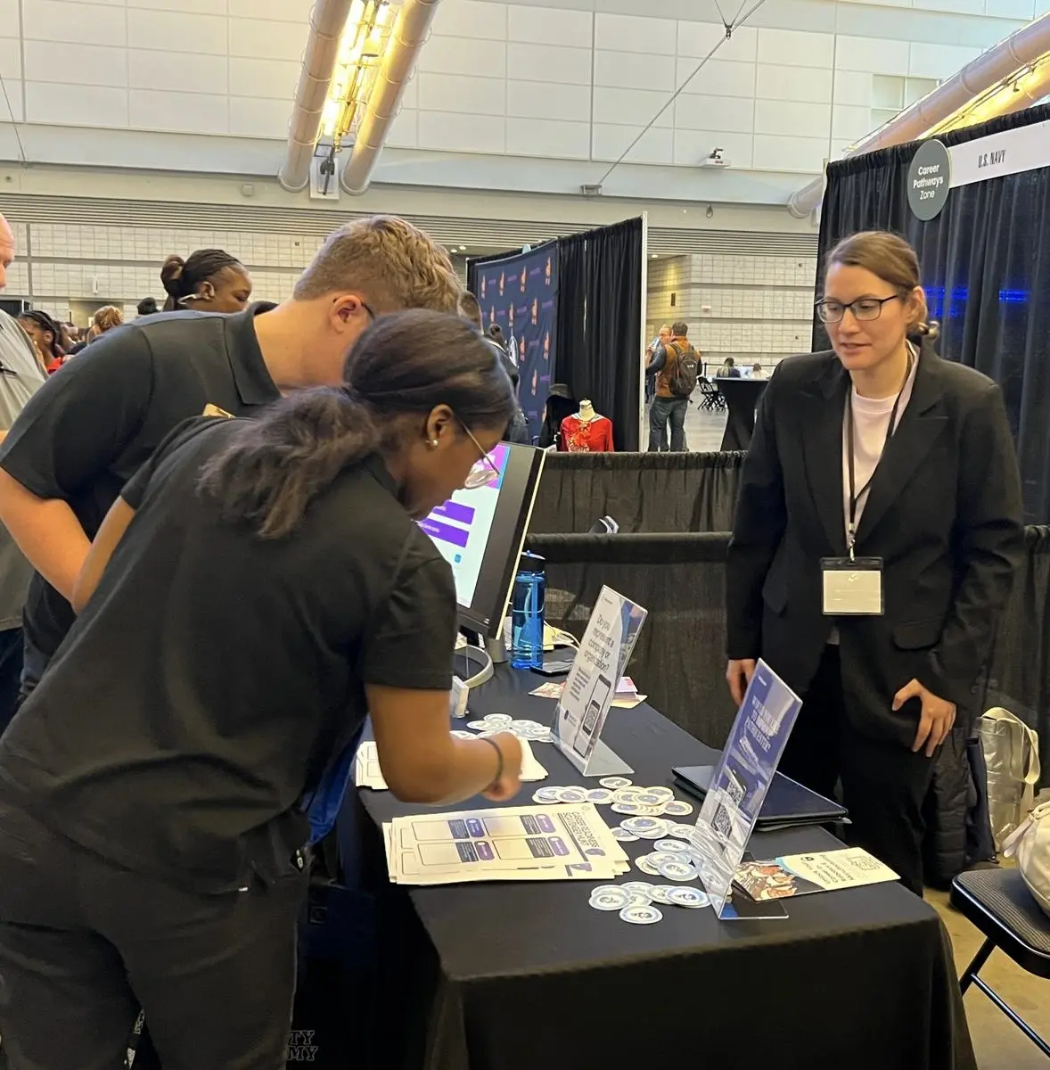 Dr. Stephanie Bowles speaking with students at the PathQuester trade-show booth